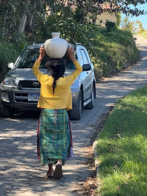 Villager demonstrates carrying a 25 lb vessel on your head.